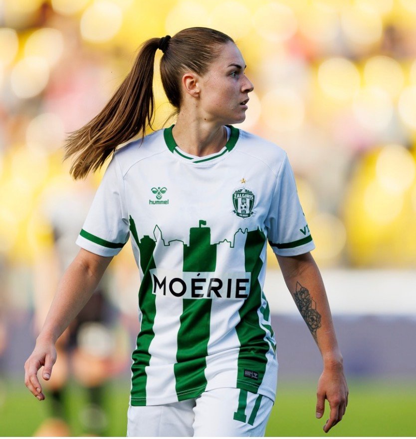 Footballer in a green and white kit on the pitch