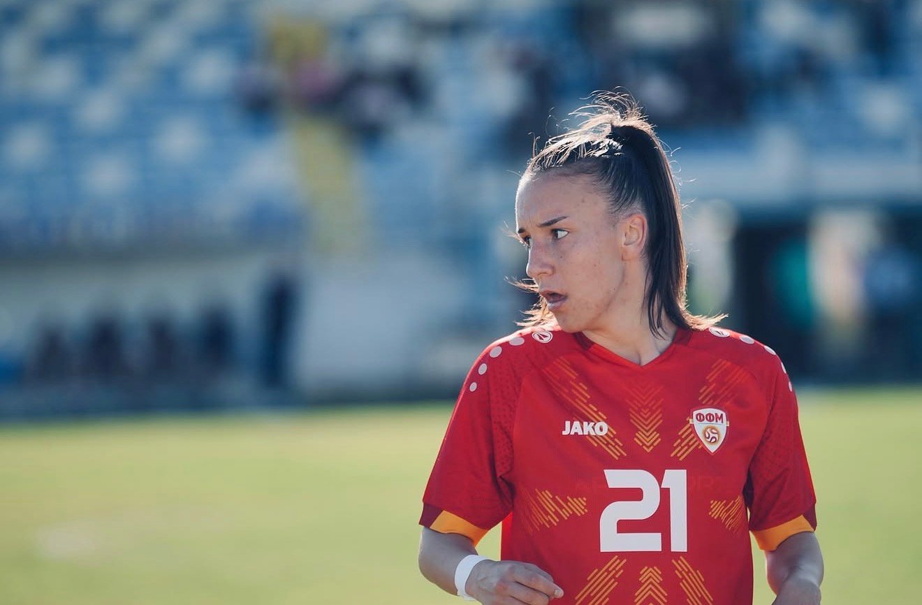 Footballer in a red kit on the pitch