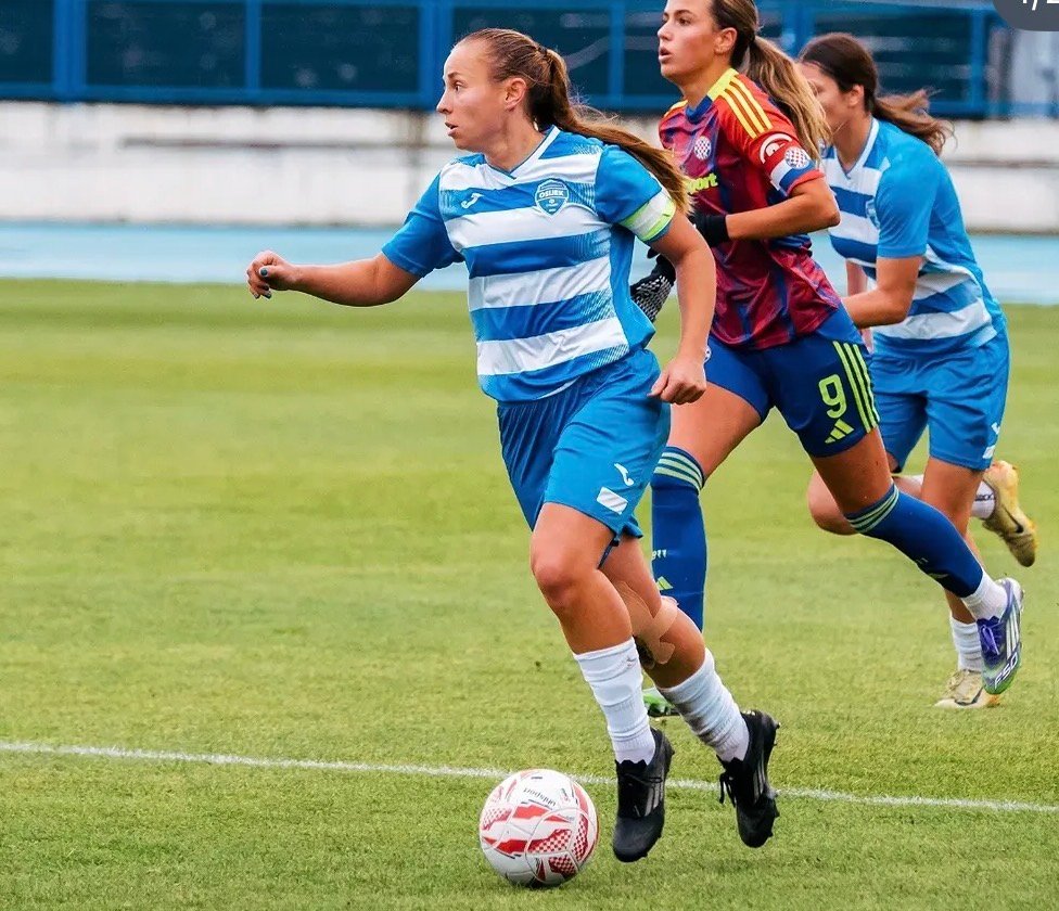 Footballer in a blue and white kit competing in a match