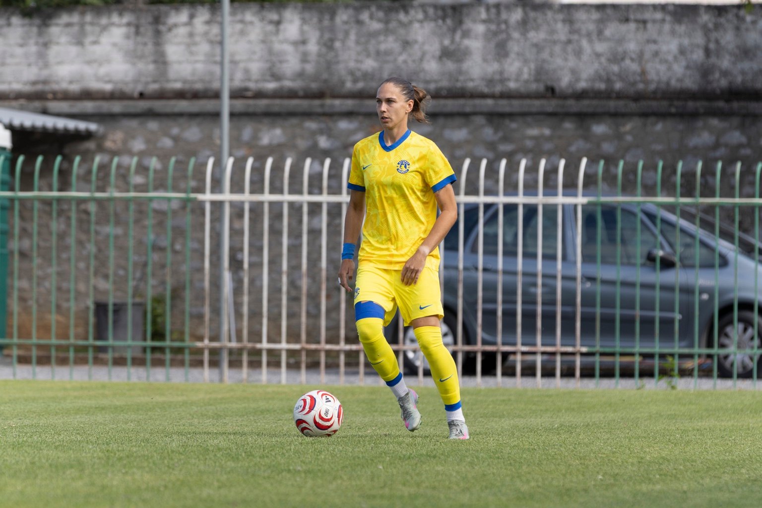 Footballer in a yellow kit on the pitch